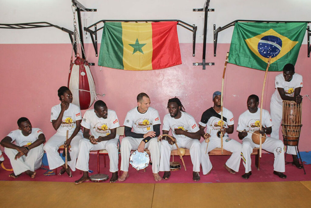 Capoieristas sitting on a bench during a capoeira batizado em Daka Senegal